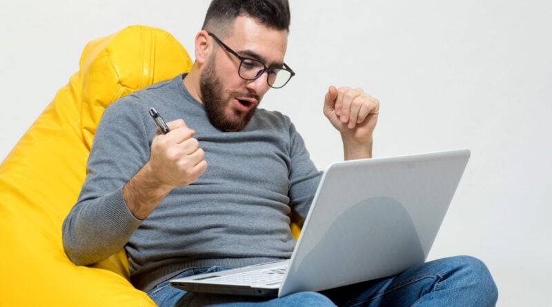 um cara se alegra enquanto trabalha no laptop CS:GO